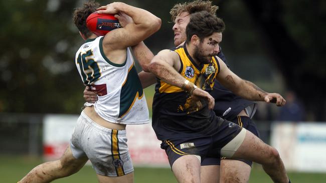 Northcote Park’s Luke Svarc collides with Matthew Atta and Jai Robinson from Whittlesea. Picture: Richard Serong.