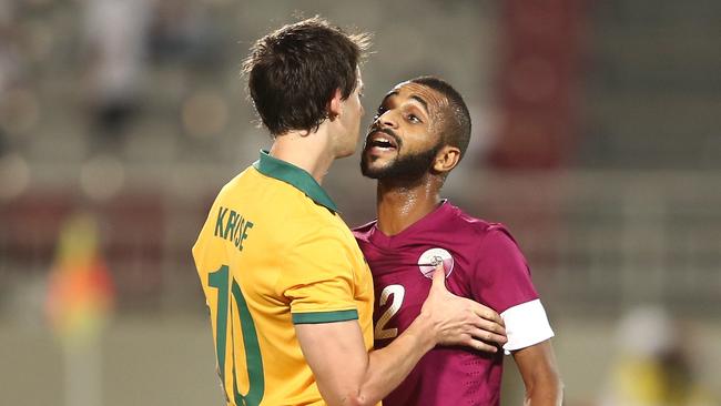 Robbie Kruse and Majed Mohammed of Qatar exchange words in October’s friendly.