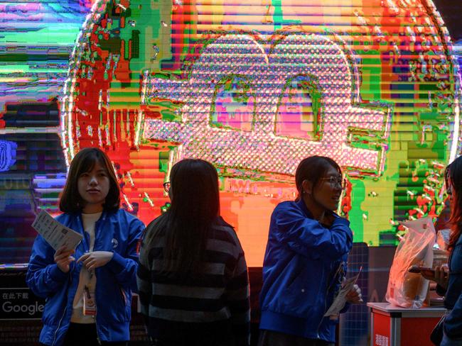 Employees talk to bypassers in front of a Bitcoin exchange advertisement truck in Hong Kong on November 27, 2024. (Photo by Mladen ANTONOV / AFP)