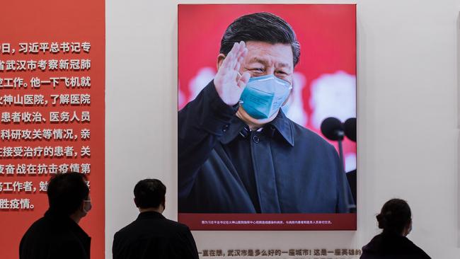 A picture of China's President Xi Jinping with a face mask is displayed as people visit an exhibition about China’s fight against COVID-19 at a convention centre that was previously used as a makeshift hospital for patients in Wuhan. Picture: Nicolas Asfouri/AFP