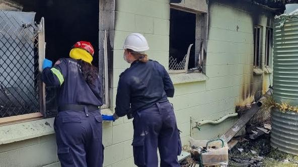 A joint investigation into a house fire at Koah was underway on February 28, between Queensland Fire and Rescue Service and Queensland Police at Barron St, Koah, on February 28, 2023. QFES Fire Investigator Aeron Holzhauser (in red and yellow helmet) with a Mareeba Scenes of Crime officer (white helmet) conduct their investigation. Picture: Supplied