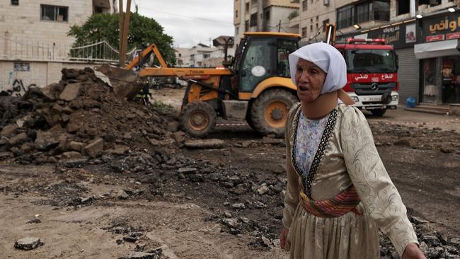 A Palestinian woman walks through a road bulldozed by the Israeli army after a raid on the refugee camp of Jenin in the occupied West Bank on January 25, 2024. Picture: Jaafar ASHTIYEH / AFP