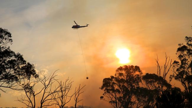 Helicopters water bomb a bush fire at Alfords Point and Menai. Picture by Damian Shaw