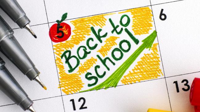 Reminder Back to School in calendar with colour pens. Close-up.