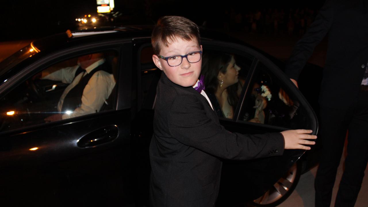 A young doorman helps the couples out at the St John's Formal in Roma.