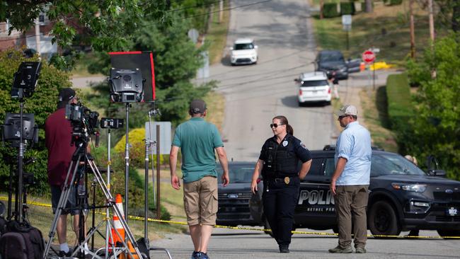 A Bethel Park police officer talks to media members about road closures around Thomas Matthew Crooks' home. Picture: AFP