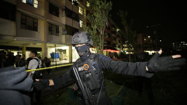 Indonesian police clear the area in front of an apartment building after an explosion in Sidoarjo. Picture: AP