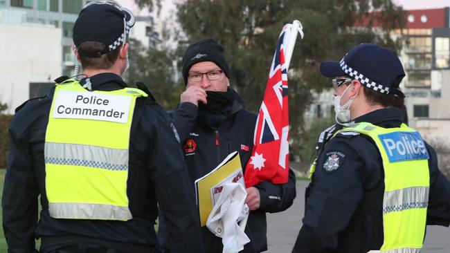 Police approach a protester at the Shrine. Picture: David Crosling