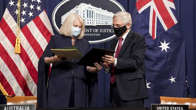 US Attorney General Merrick Garland (R) and Australian Minister for Home Affairs Karen Andrews (L) exchange documents after entering into a new law enforcement partnership at the US Department of Justice in Washington. Picture: AFP.