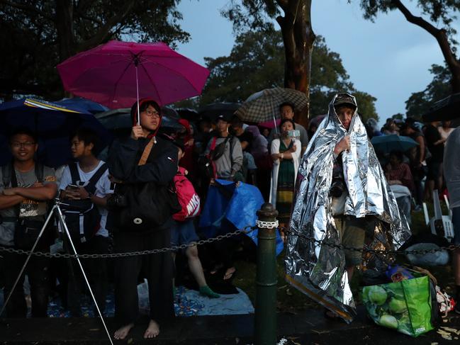 NYE revellers huddle under covers as heavy rains pass over sydney harbour Picture Jonathan Ng