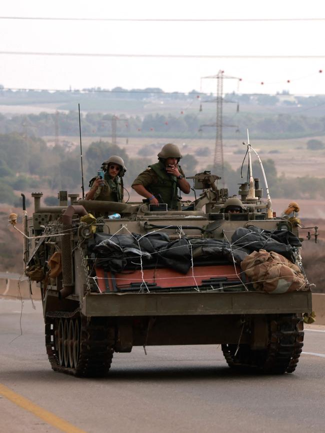 Israeli soldiers ride in their armoured vehicles towards the border with the Gaza Strip on October 16. Picture: Menahem Kahana/AFP