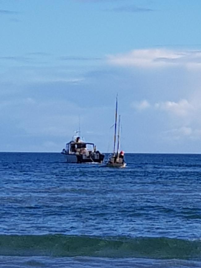 Away she goes ... the yacht is towed to a boat ramp. Picture Mark Young