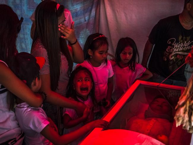 Six-year-old Jimji, cries out in anguish as workers move the body of her father, Jimboy Bolasa, 25, for burial, in Manila. Picture: Daniel Berehulak/The New York Times/Redux/Headpress
