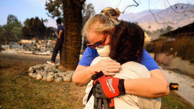 Danielle Maki hugs a family member while viewing her brother's burned home during the Eaton fire in the Altadena area of Los Angeles. Picture: AFP