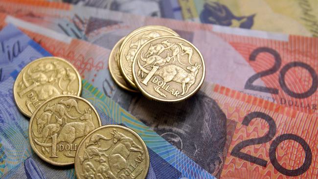 Australian one-dollar coins sit with a collection of bank notes arranged for a photograph, in Sydney, Australia, on Wednesday, Aug. 3, 2011. Australia's central bank may need to resume increasing the developed world's highest borrowing costs to keep inflation from accelerating as a mining boom intensifies, according to the International Monetary Fund. Photographer: Sergio Dionisio/Bloomberg