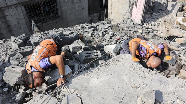 Palestinian medics search for survivors in the rubble of a building after it was hit during an Israeli strike on Gaza City's Zaytoun neighbourhood on Saturday. Picture: AFP