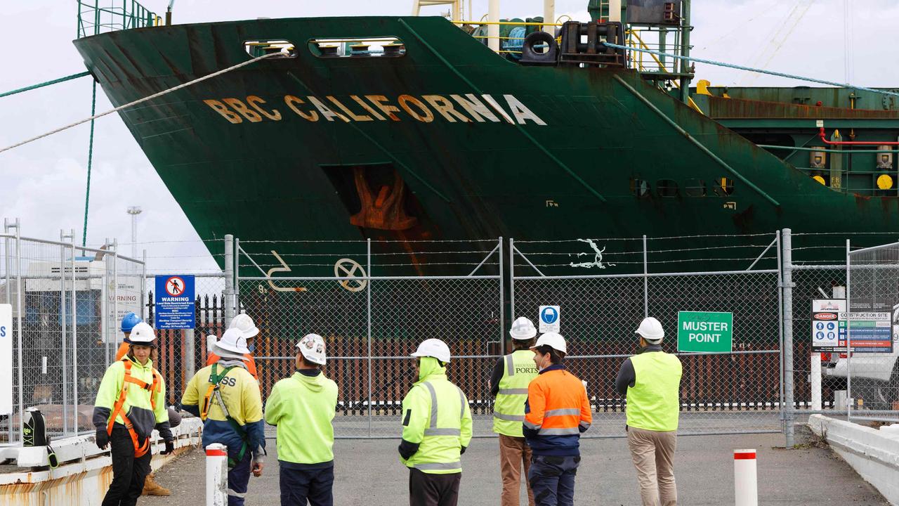 Port workers waited outside a secured area as the cargo ship docked at the port this week. Picture: Trevor Collens / AFP