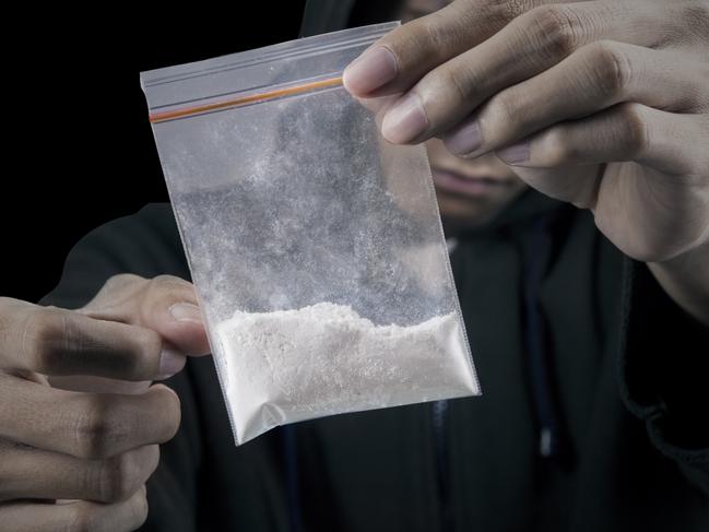 Drug dealer is preparing packet of heroin or cocaine