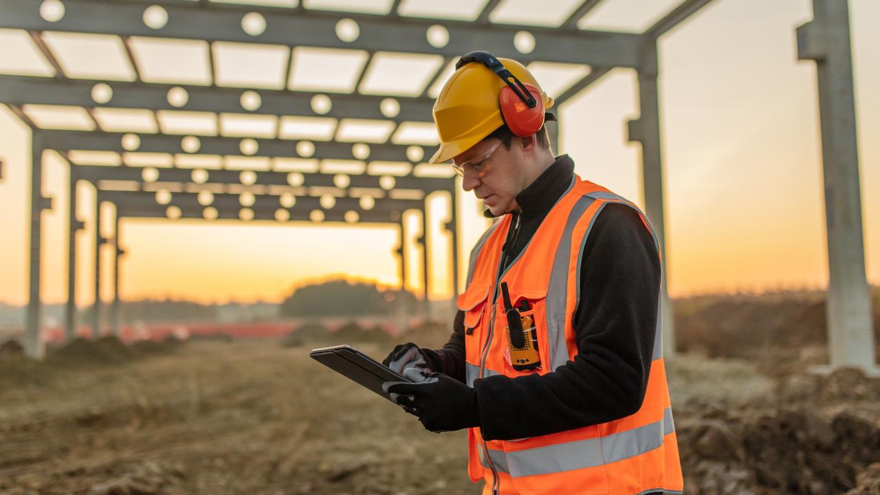 Male architect analyzing work using digital tablet at construction site