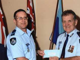 Adrian Zori (left) receives a 25 year clasp Police Service medal from Assistant Commissioner Colin McCallum in 2010.