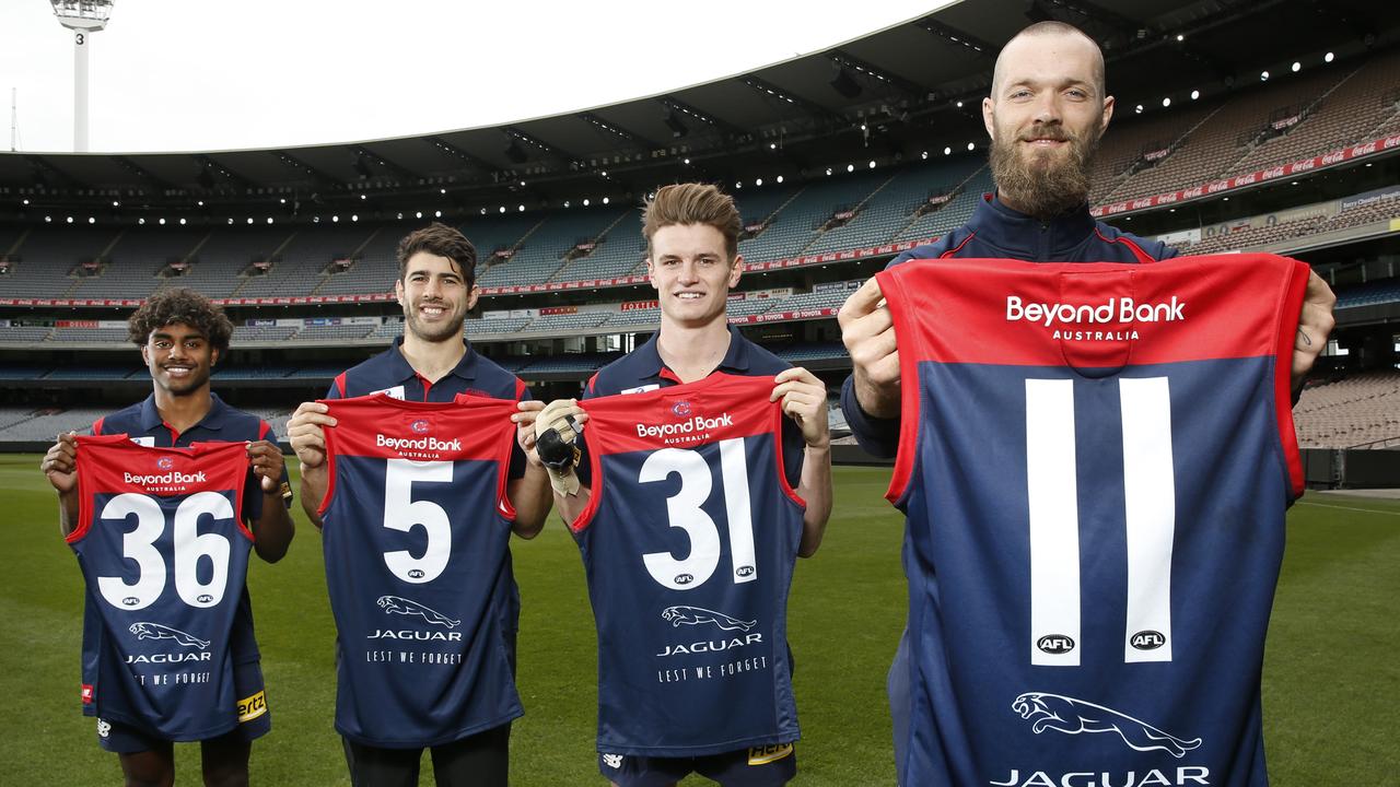 Melbourne players Kozzy Picket, Christian Petracca, Bayley Fritsch and Max Gawn hold their jumpers, with the numbers of the club’s fallen heroes. Picture: David Caird.