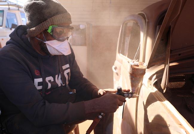 Robert Fielding sandblasting the Volkswagen car body at Mimili. Picture: Courtesy the artist and Mimili Maku Arts.