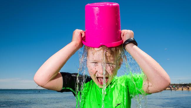 Harry Hodgetts, 7 yrs, cools off with a bucket of water at the beach. Picture: Jake Nowakowski