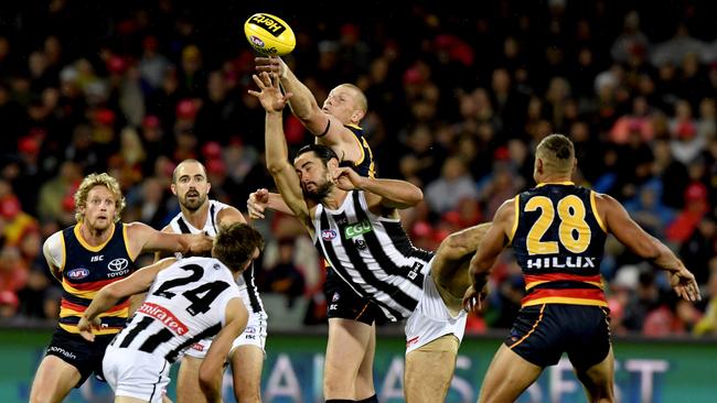 Brodie Grundy, middle, tackles Crows ruckman Sam Jacobs with Rory Sloane and Steele Sidebottom, left, waiting for the crumbs. Picture: AAP Image/Sam Wundke