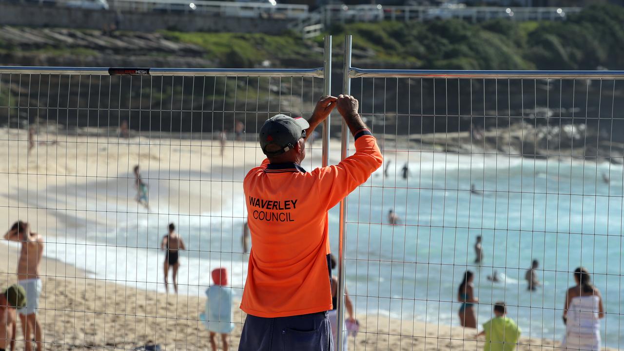 A Waverley Council worker fences off Bondi Beach, one of the areas worst affected by coronavirus in Australia.