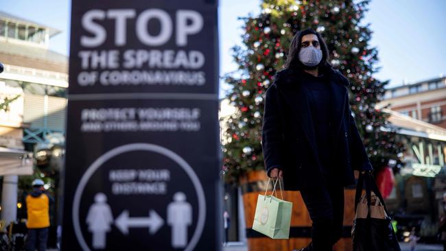 A shopper walks by a sign reminded people to social distance at Covent Garden in central London on November 22. Picture: AFP