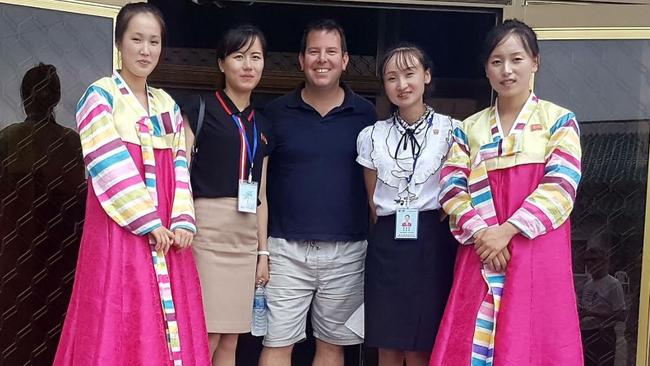 Travel Masters’ Neil Kirby in North Korea in August with two English-speaking government travel guides and two local women in traditional dress. Photo: Supplied.