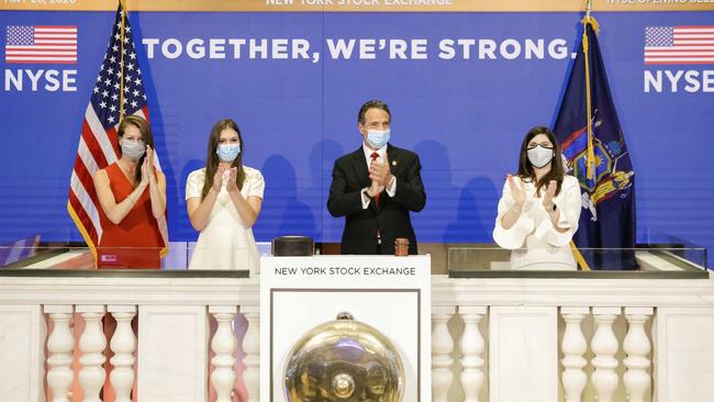 New York State Governor, centre, and New York Stock Exchange President Stacey Cunningham, right, applaud as the trading floor reopens. Picture: AP