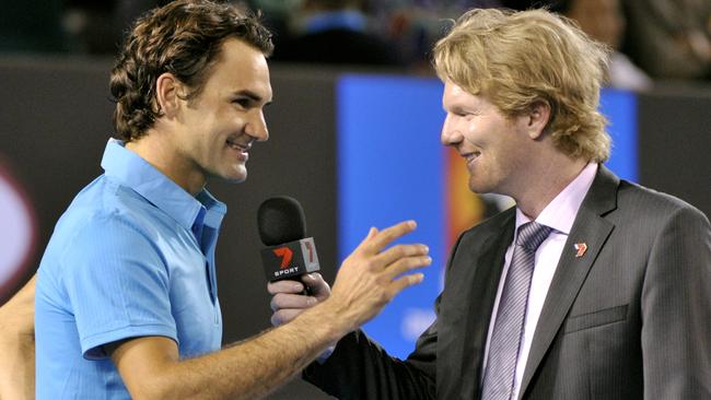 Roger Federer and Jim Courier share a joke. Picture: AP Photo 