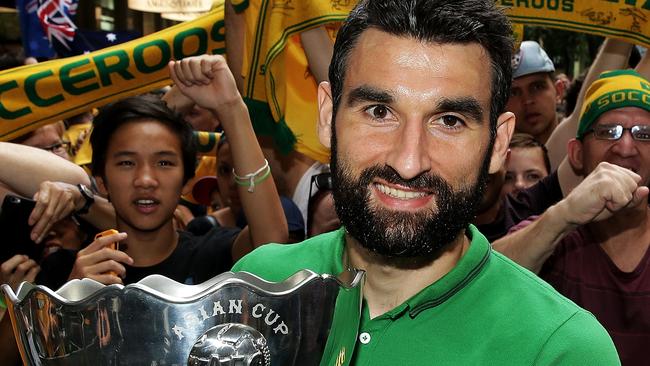 Socceroos captain Mile Jedinak celebrates with fans the morning after.