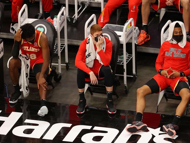 ATLANTA, GEORGIA - FEBRUARY 12: Solomon Hill #18, Kevin Huerter #3 and John Collins #20 of the Atlanta Hawks look on from the bench in the fourth quarter of their 125-114 loss to the San Antonio Spurs at State Farm Arena on February 12, 2021 in Atlanta, Georgia. NOTE TO USER: User expressly acknowledges and agrees that, by downloading and or using this photograph, User is consenting to the terms and conditions of the Getty Images License Agreement.   Kevin C. Cox/Getty Images/AFP == FOR NEWSPAPERS, INTERNET, TELCOS & TELEVISION USE ONLY ==