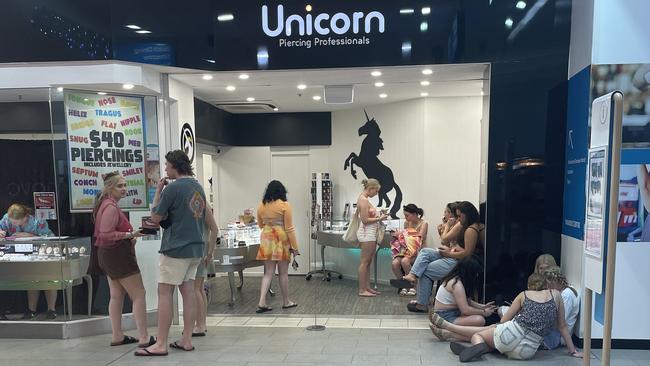 Schoolies wait for piercings and tooth gems in the Paradise Centre. Picture: Georgina Noack