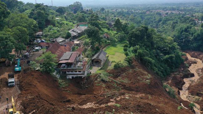 Workers heavy equipments to remove soil following landslide triggered by a 5.6-magnitude earthquake near Cianjur. Picture: AFP