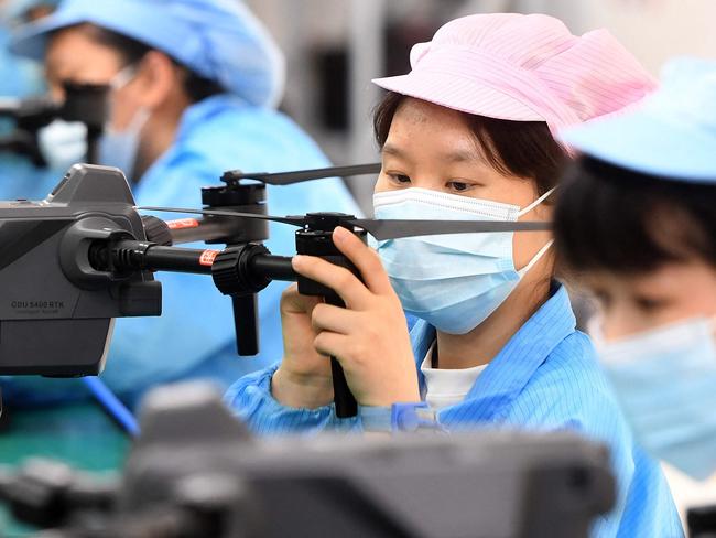 This photo taken on April 13, 2023 shows workers producing drones at a factory in Wuhan, in China's central Hubei province. (Photo by AFP) / China OUT