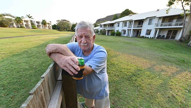 A quiet beer for relieved Villa owner Chris Shannon resting on the wood fence built to separate them form the gold course (to the left of frame), outside his villa, at the Palmer Coolum Resort. Picture: Lyndon Mechielsen