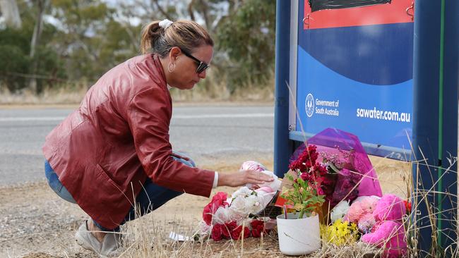 Another woman lays flowers at the Whispering Wall sign. Picture: NCA NewsWire / David Mariuz