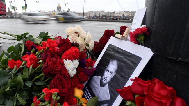 A portrait of Russian military blogger Vladlen Tatarsky, whose real name is Maxim Fomin, who was killed in the April 2 bomb blast in a cafe, is seen among flowers at a makeshift memorial by the explosion site in Saint Petersburg.