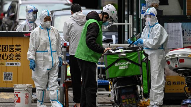 Workers are seen at the entrance of a neigborhood during a Covid-19 coronavirus lockdown in the Jing'an district in Shanghai. Picture: AFP