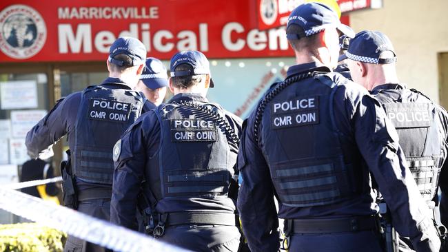 Police sweep the area for evidence in Marrickville Road, Marrickville. Picture: John Appleyard