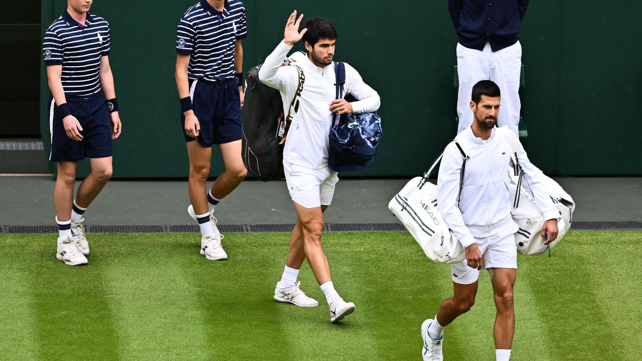 Spain's Carlos Alcaraz and Serbia's Novak Djokovic arrive in the court to play the men's singles final. (Photo by SEBASTIEN BOZON / AFP)