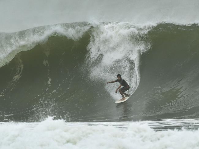 A surfer takes advantage of the giant swells at Collaroy. Picture: AFP