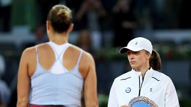 Iga Swiatek of Poland with the runner up trophy as Aryna Sabalenka walks up to collect the winners trophy. (Photo by Clive Brunskill/Getty Images)