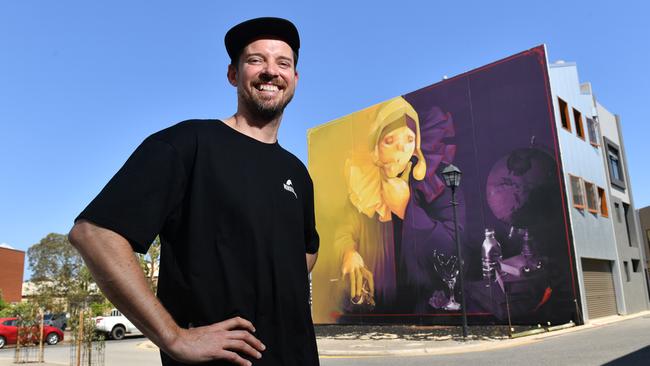 Wonderwalls Festival chief Joel van Moore with one of his favourite murals in the district. He hopes to involve more artists in his celebration of street art and graffiti. Picture: AAP/KERYN STEVENS