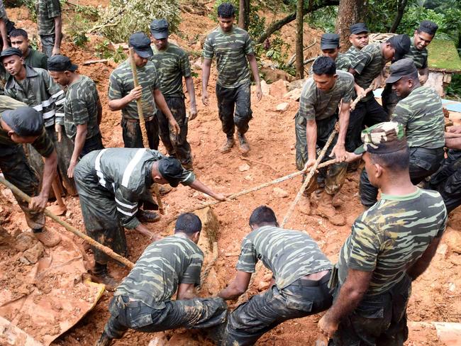 TOPSHOT - Sri Lankan military personnel take part in relief and rescue efforts following a landslide in the village of Bulathkohupitiya on May 18, 2016. Rescue workers on May 18 recovered the bodies of 17 villagers buried in landslides in Sri Lanka after three days of torrential rain. The disaster hit two small villages in Kegalle, a mountainous area northeast of Colombo, and takes the overall death toll from flooding and landslides in recent days to 36. / AFP PHOTO / STR