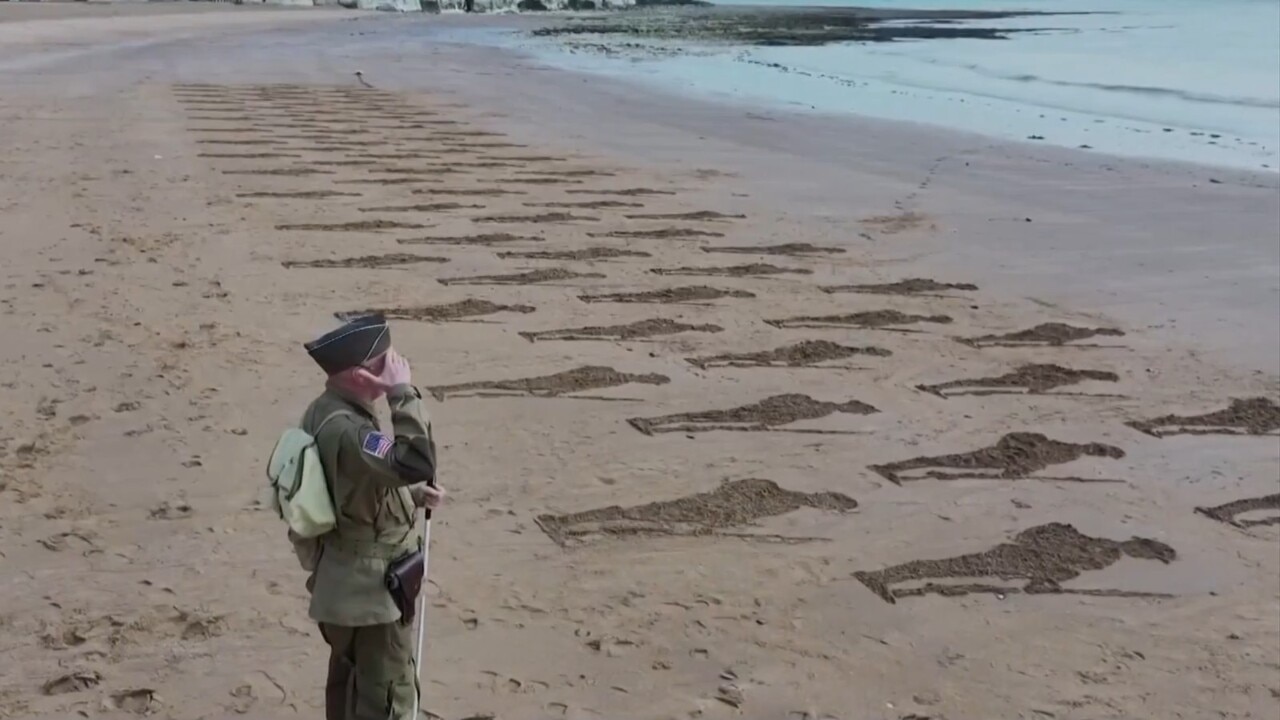 Silhouettes of WWII soldiers engraved on UK beach