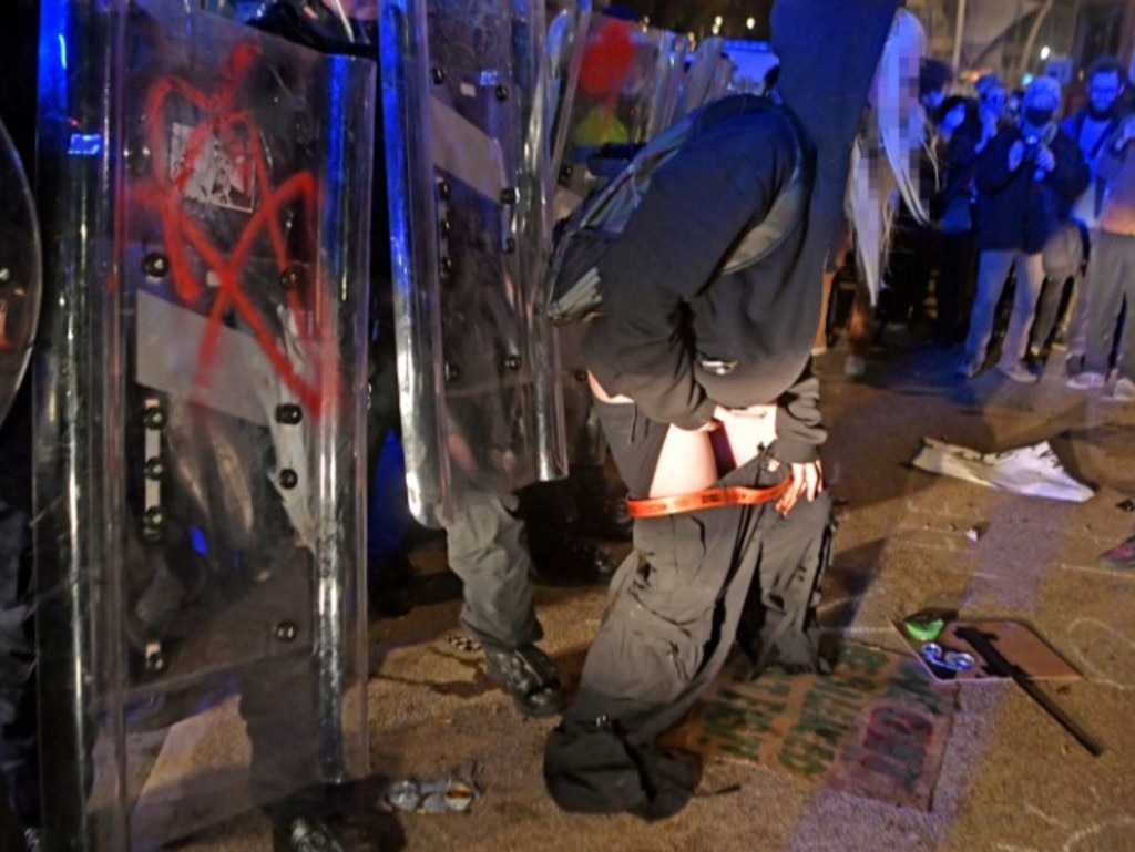 A female protester with her pants down in front of police officers. Picture: BPM/Australscope